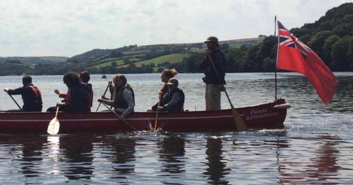 Canoeing on the River Dart in 12-seater vessels belonging to Canoe Adventures