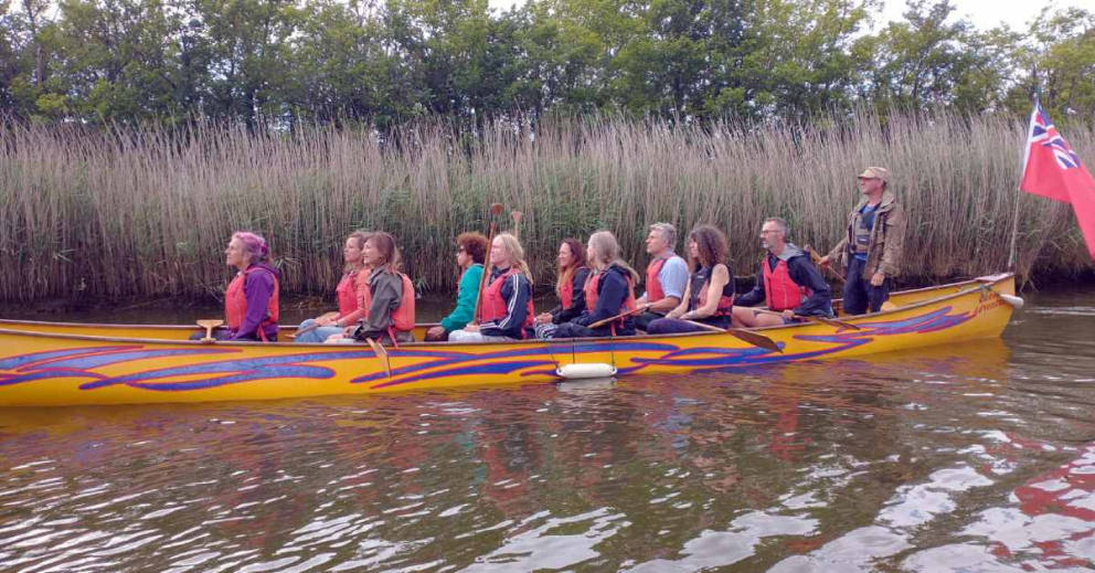 Canoeing on the River Dart in 12-seater vessels belonging to Canoe Adventures