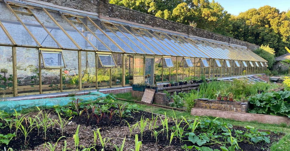 View of the glasshouse in the Walled Garden at The Sharpham Trust mindfulness retreat centre
