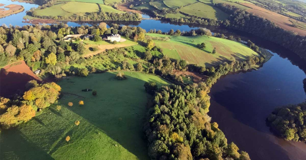 Sharpham House with a newly-planted wildflower meadow in front