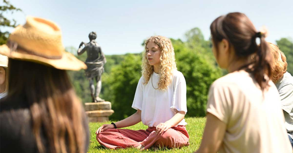 Retreatants meditating outside on a Coach House retreat at The Sharpham Trust