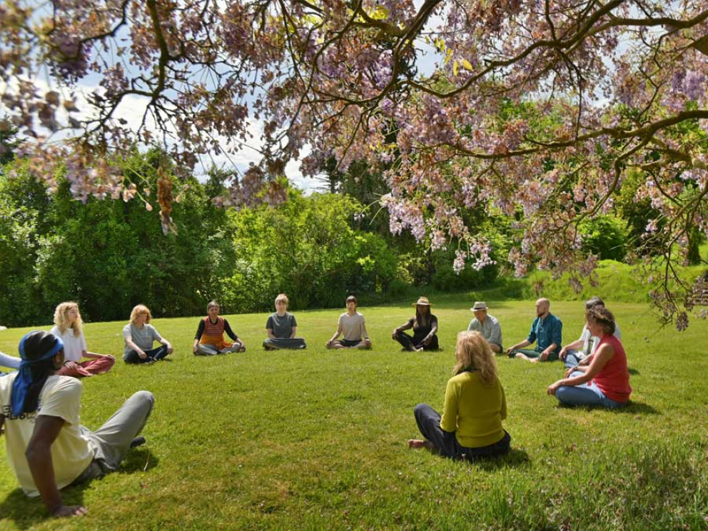 a meditation group beneath the wisteria at Sharpham