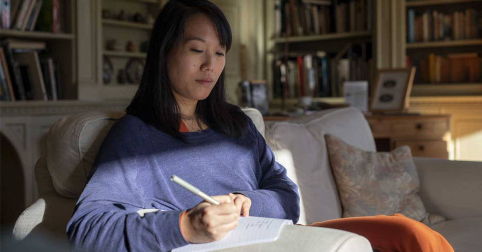 A retreatant journalling in the library at Sharpham House