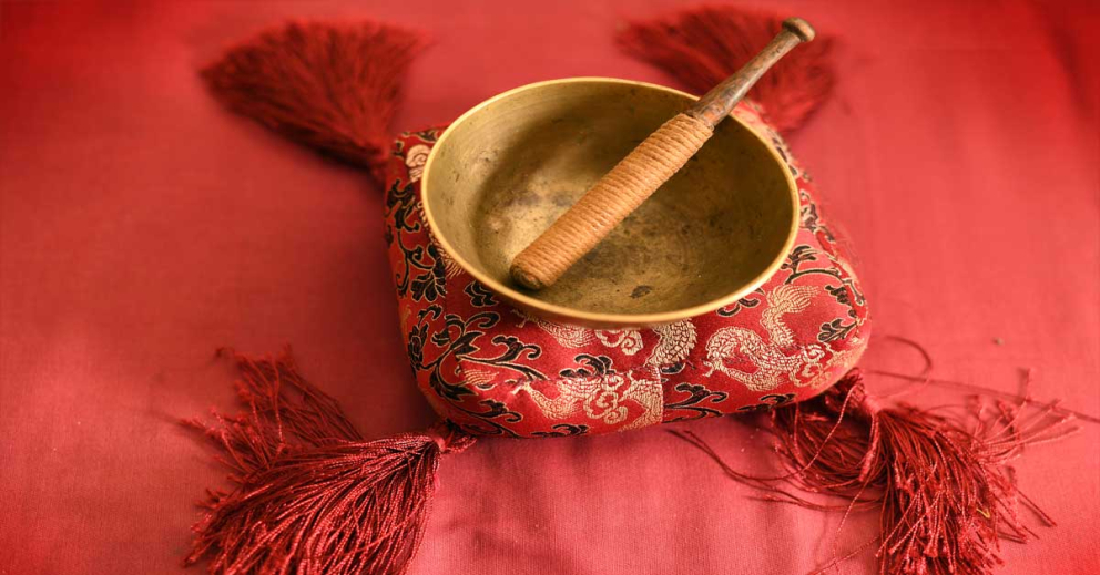 A singing bowl on a red background at The Barn retreat centre at Sharpham