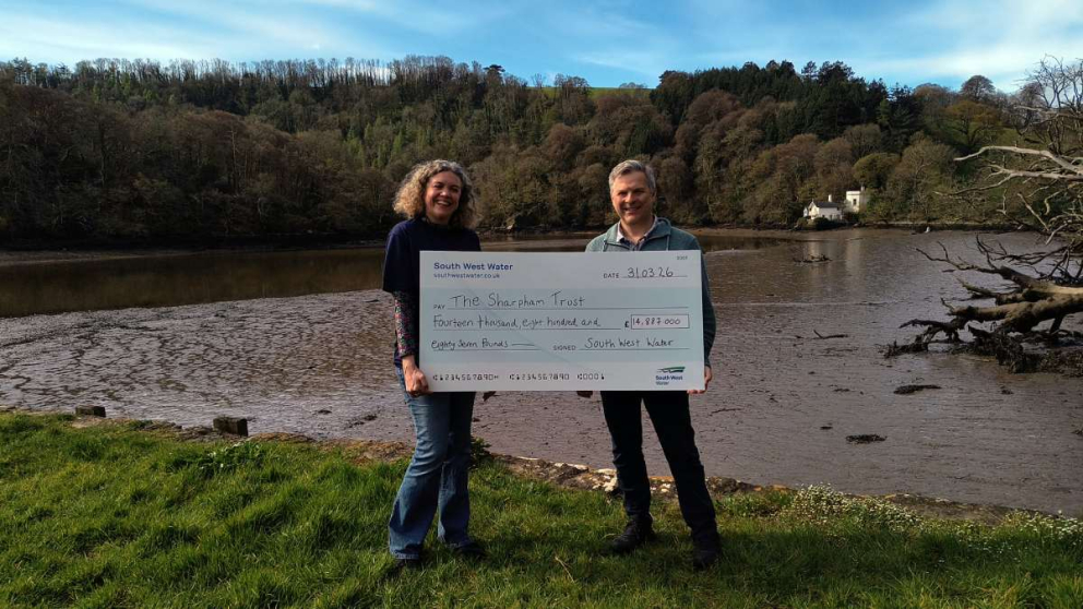 Trust Director Julian Carnell receives a cheque for nearly £15k from Kristy Poulton from South West Water's Better Futures Fund